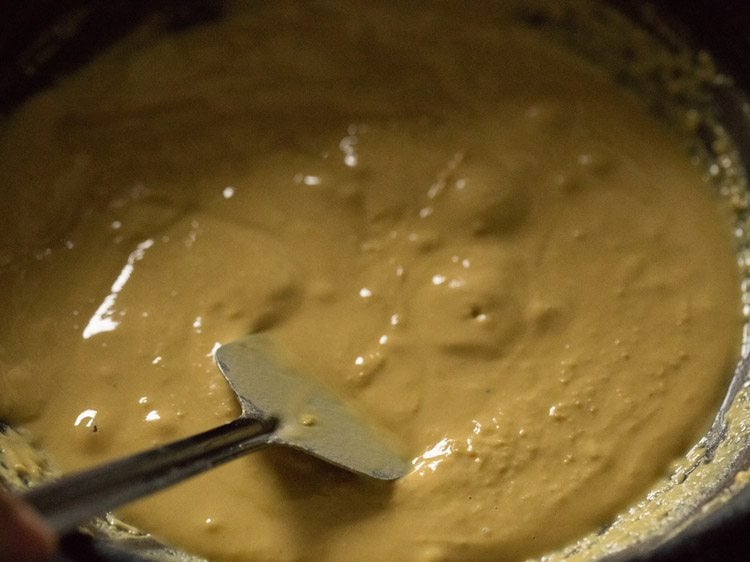 stirring and frying besan mixture for besan barfi recipe. 