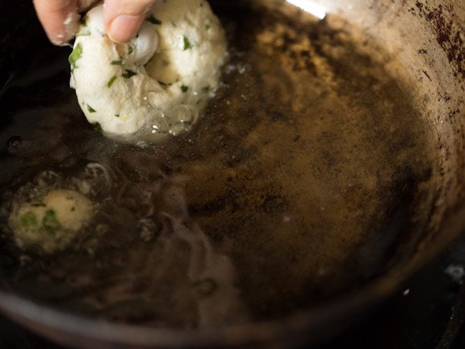 adding prepared rava vada in hot oil. 