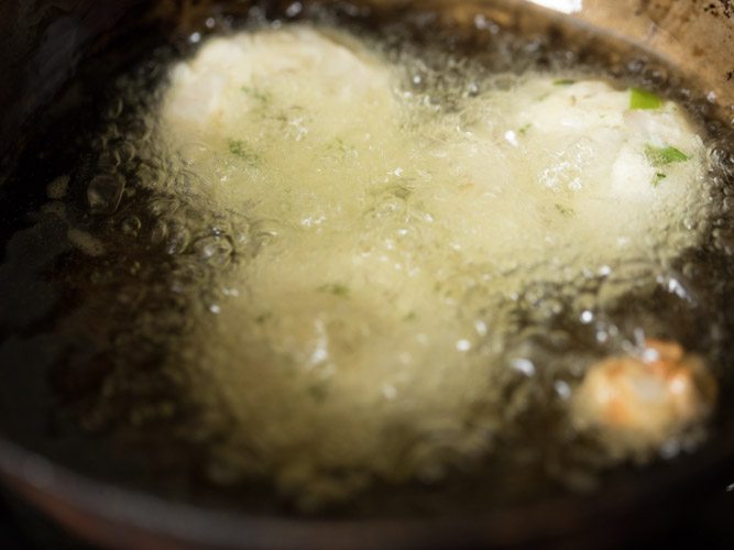 frying vadas in hot oil in pan. 