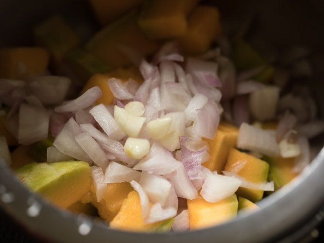 pumpkin cubes, onions and garlic in a pressure cooker.