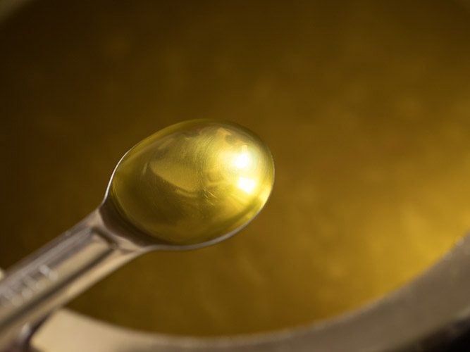 olive oil being added to blended pumpkin soup. 