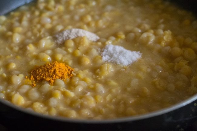 turmeric powder, asafoetida and salt added to cooked white peas. 