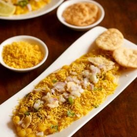 ragda chaat served with 2 papdis on a white platter with text layover.