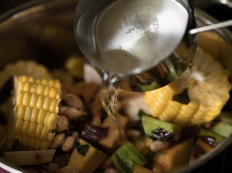 adding water to the pan for rushichi bhaji. 