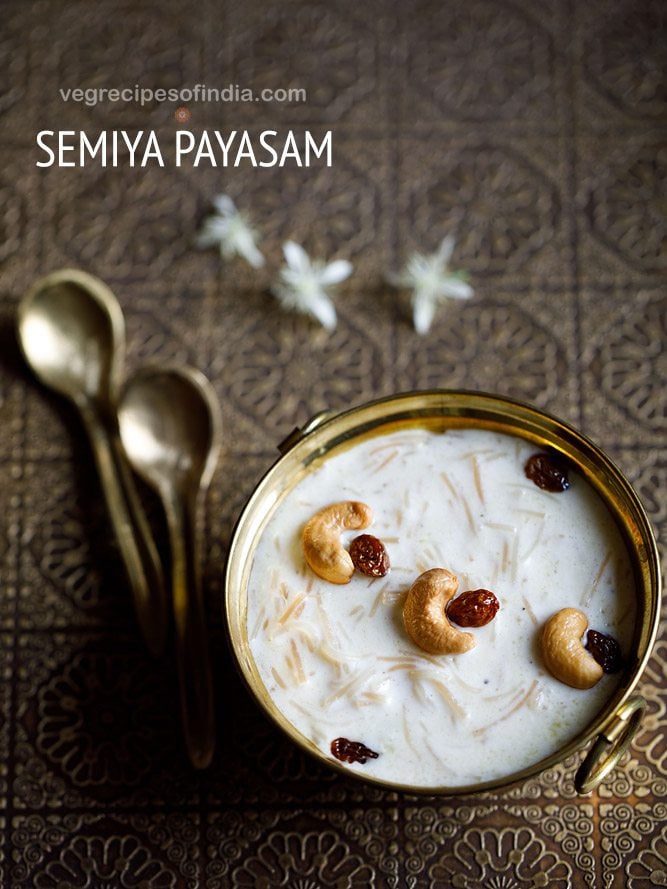 semiya payasam garnished with cashews and raisins in a brass bowl on a brass tray with small brass spoons and white flower on the tray