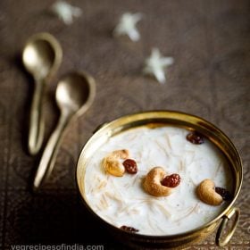 semiya payasam garnished with cashews and raisins in a brass bowl on a brass tray with small brass spoons and white flower on the tray
