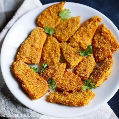 suran fries arranged on a white plate and garnished with coriander leaves placed on a grey and white napkin