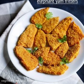 yam fries arranged on a white plate and garnished with coriander leaves placed on a grey and white napkin on a dark blue board with a text layover