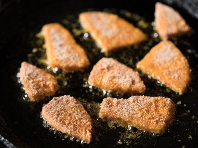 yam slices placed on hot oil in a skillet