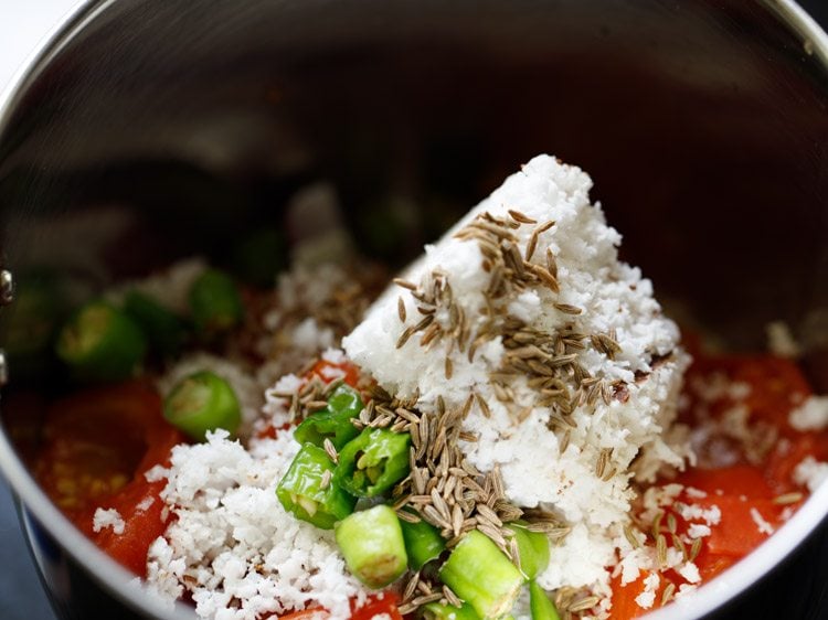 fresh grated coconuts, chopped green chilies and cumin seeds added to the tomatoes in the grinder jar. 