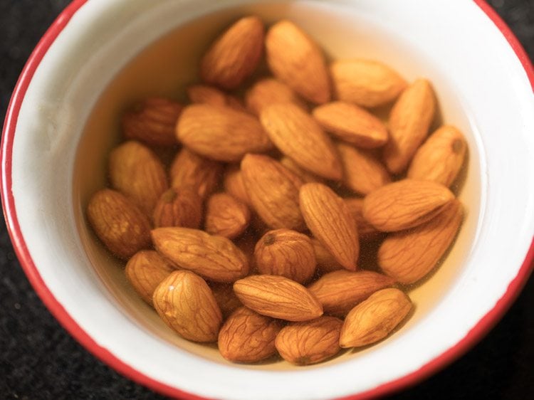 blanching almonds in hot water for badam kheer recipe.