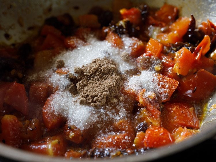 sugar and dried mango powder added to the tomato-date mixture. 