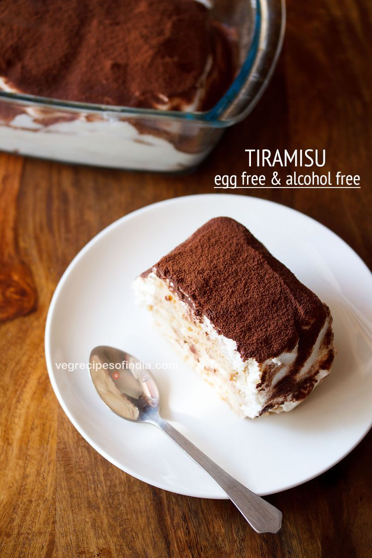 slice of tiramisu on a round white plate with a silver spoon on a wooden table