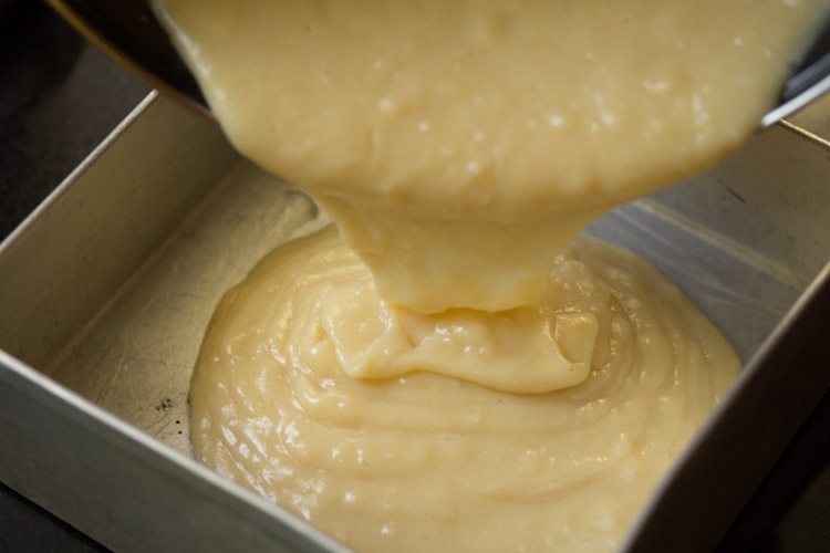 pouring sponge batter into prepared baking pan