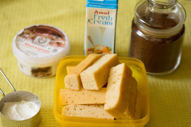 ingredients for making tiramisu recipe set out on a yellow cloth