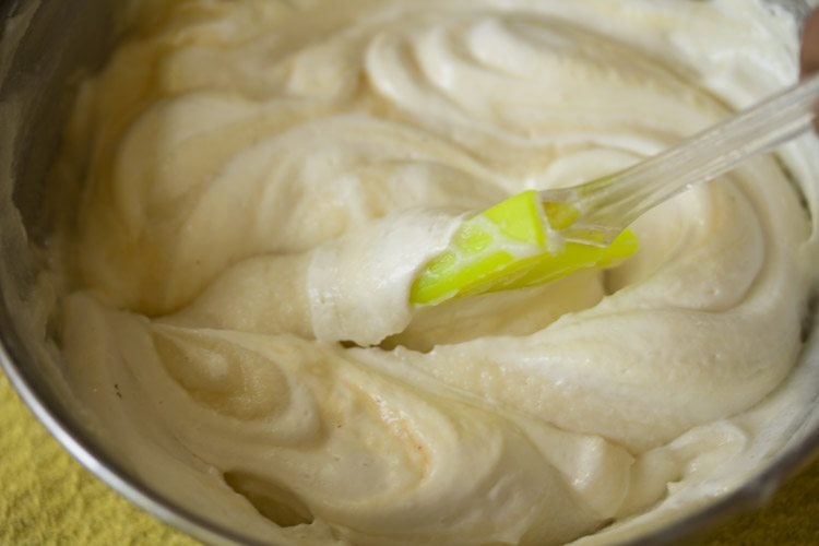 spatula folding cream and mascarpone together for eggless tiramisu filling