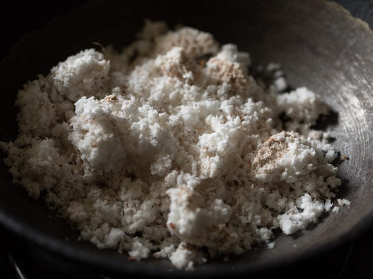 fresh grated coconut added to a pan on low heat. 