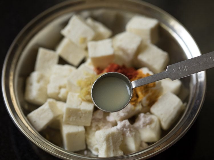 adding lemon juice to paneer cubes. 