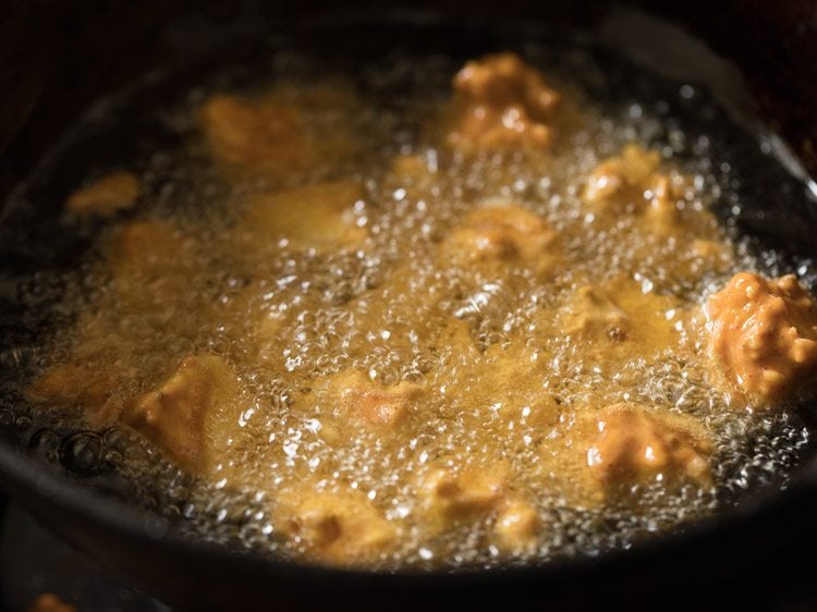 deep frying paneer cubes in hot oil. 