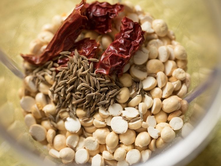 roasted chana dal, dried red chili and cumin seeds added to a grinder jar for ribbon pakoda recipe. 