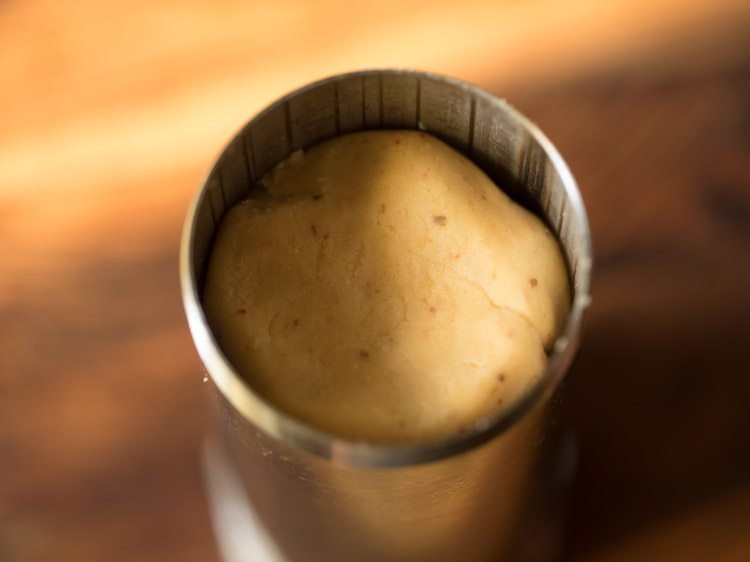 a portion of prepared dough placed inside the murukku maker. 