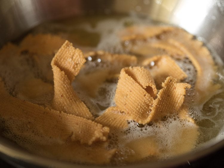 frying murukkus till crisp and golden.  
