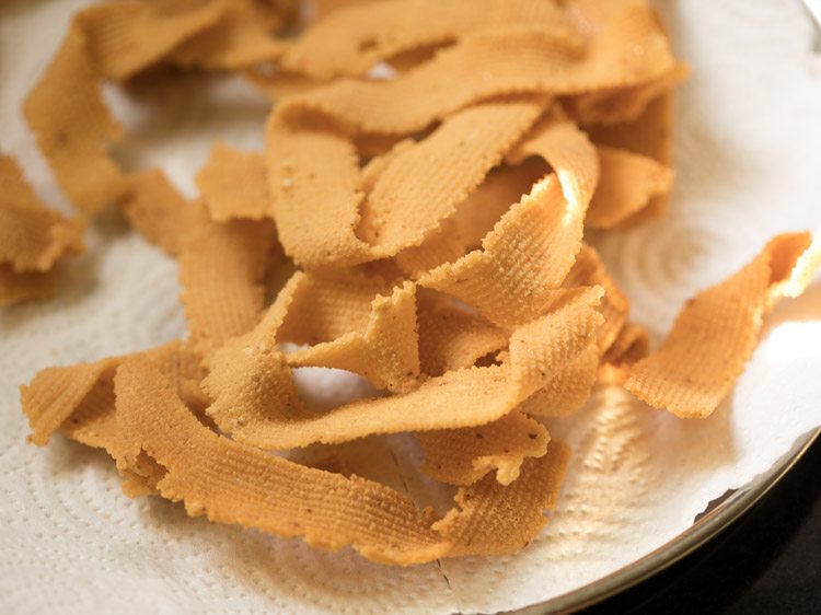 fried ribbon murukku placed on kitchen paper towel. 