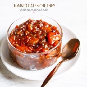 tomato khejur chutney served in a glass bowl kept on a white plate with a spoon on the right side and text layovers.