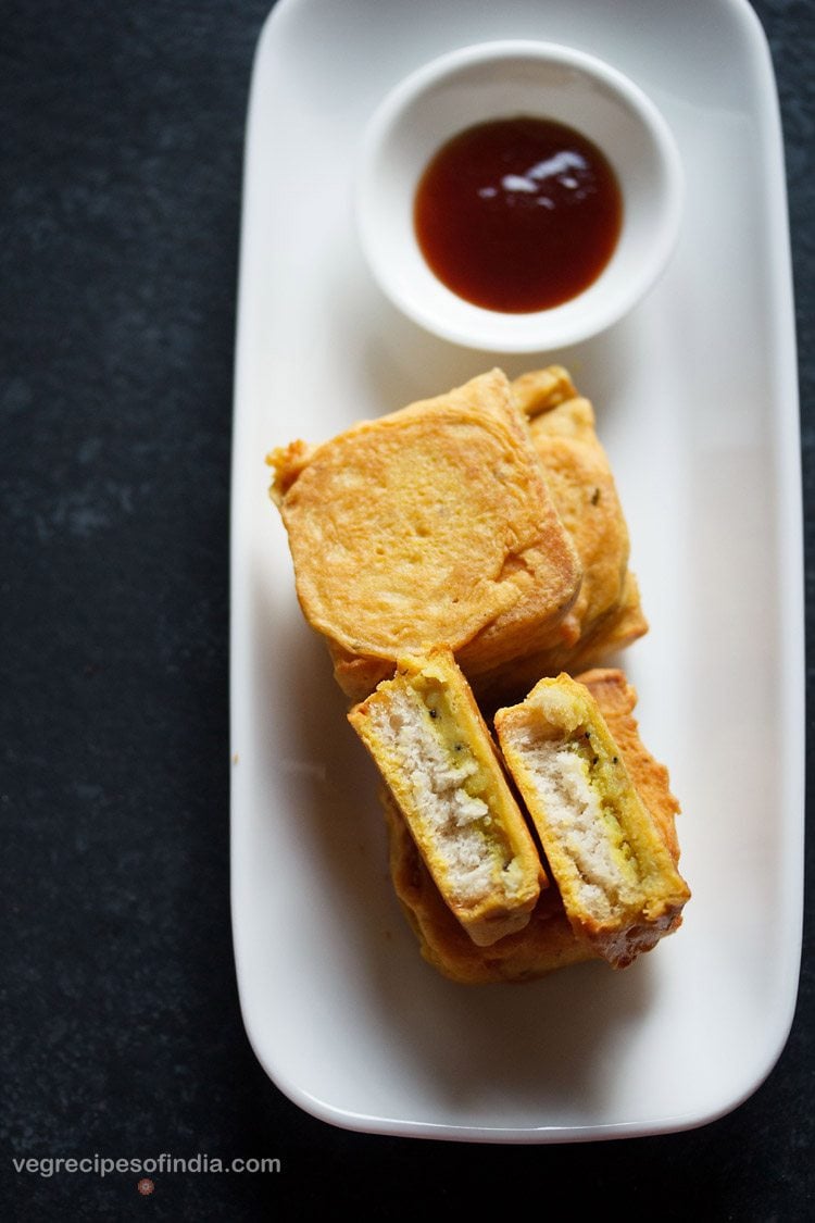 potato bread pattice served on a white platter, with one pattice halved, a small bowl of sweet date-tamarind chutney kept on the top on the platter and text layover. 