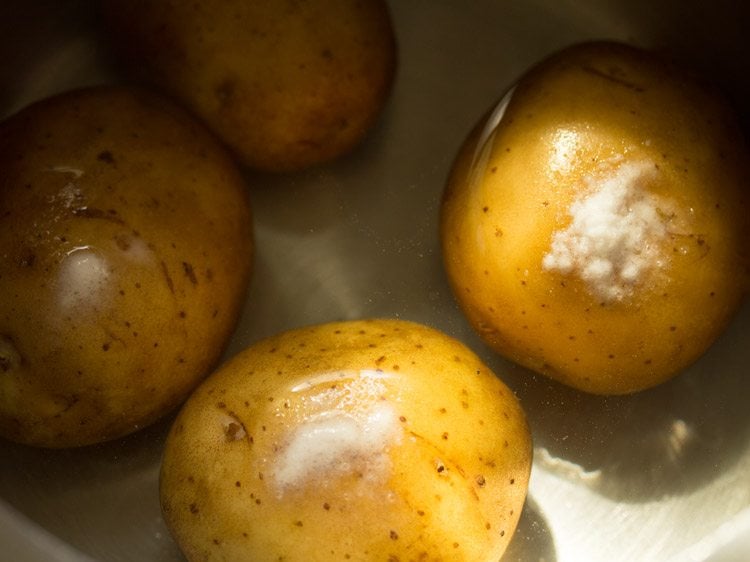 rinsed potatoes and salt added to a pressure cooker for making bread patties. 