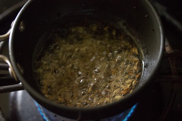 ura dal and cumin seeds added to crackling mustard seeds in hot oil. 