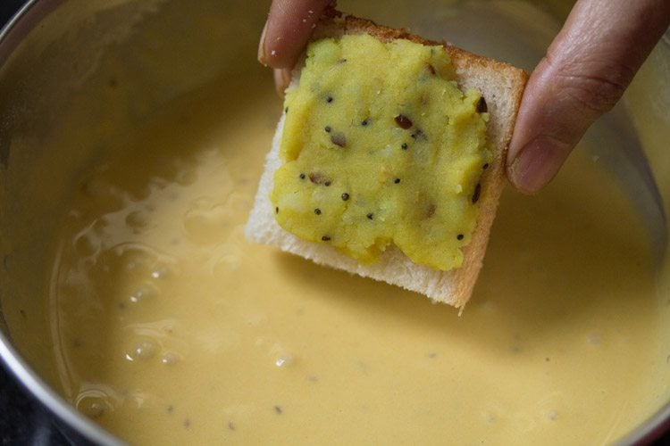 dipping potato mixture topped bread piece in the prepared batter. 