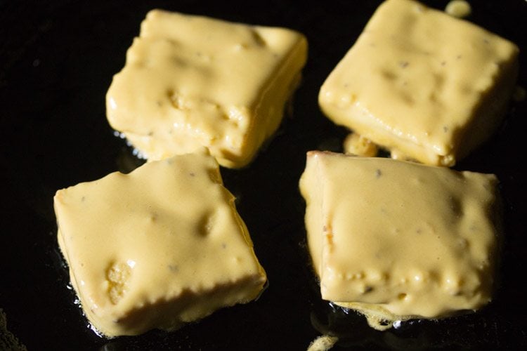 batter coated bread pieces placed on hot oil io a thick bottomed pan. 