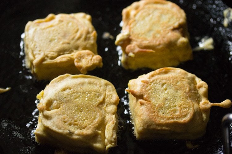 frying batter coated bread pieces from the other side. 