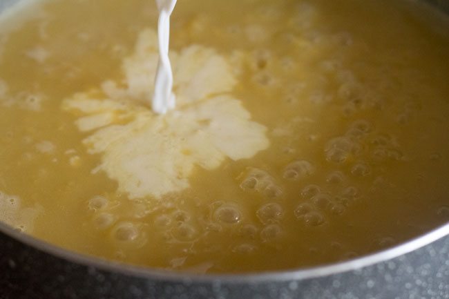 adding thick coconut milk after jaggery dissolves.