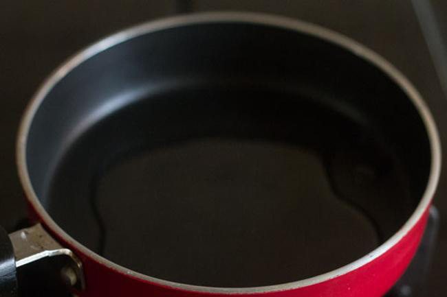 heating ghee in a small pan for making tadka for kadalai paruppu payasam.