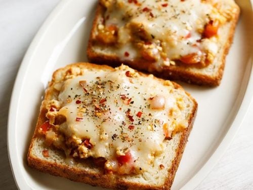 paneer toast served on a white platter with a small bowl of tomato ketchup kept on the top left side and text layovers.