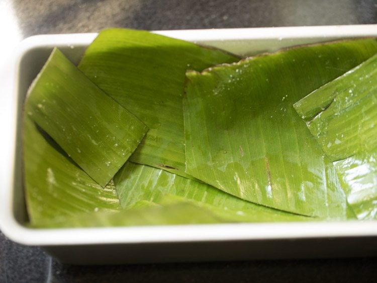 cake pan lined with greased banana leaves for making chenna poda. 