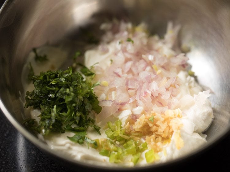 chopped onions, ginger, green chilies, coriander and curd in a bowl