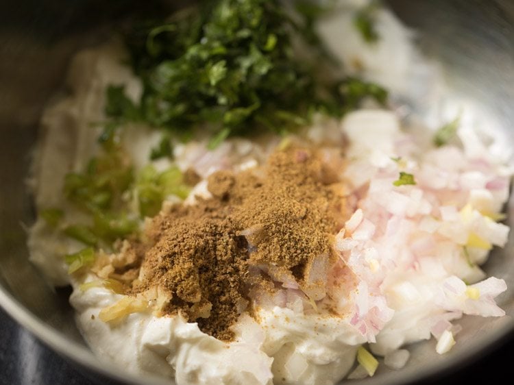 chopped onions, ginger, green chilies, coriander, cumin and curd in a bowl