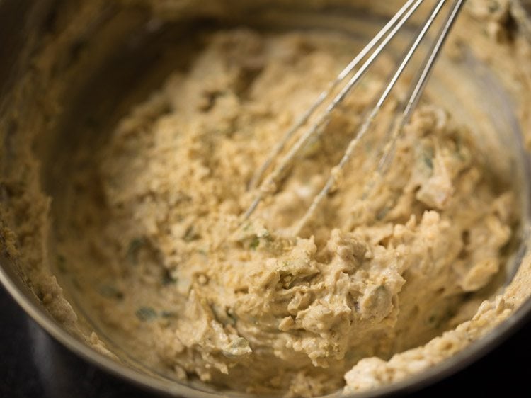 chopped onions, ginger, green chilies, coriander, cumin, besan, pepper and curd whisked in a bowl