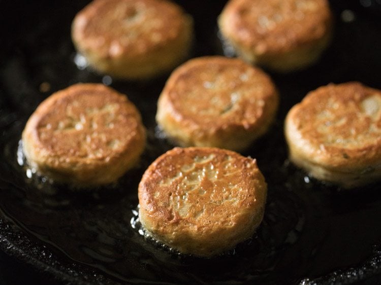 golden dahi kabab frying in a pan