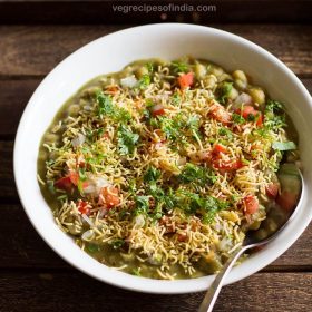 masala puri chaat served in a white bowl with a spoon in it.