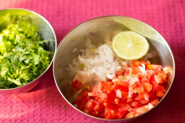 chopped onions tomato lime and corinader leaves in 2 bowls