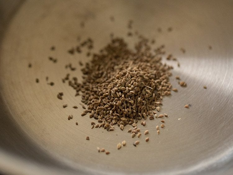 carom seeds added to a hot pan for making omapodi. 