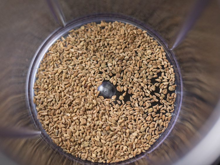 roasted carom seeds added to a grinder jar. 
