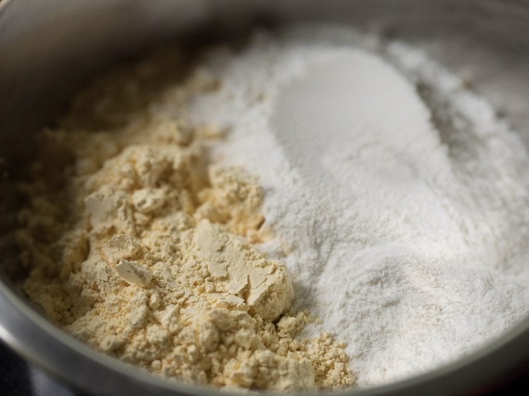 gram flour and rice flour added to a mixing bowl for making omapodi. 