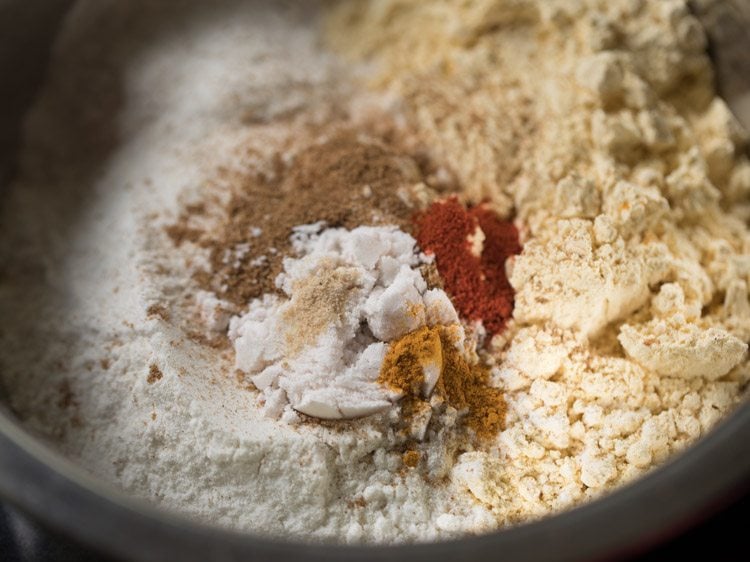 asafoetida, turmeric powder, red chili power and salt added to the bowl for making dough for omapodi recipe.  