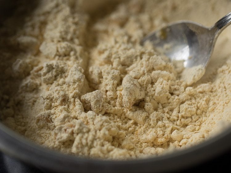 mixing the oil into the flour mixture, with a spoon. 