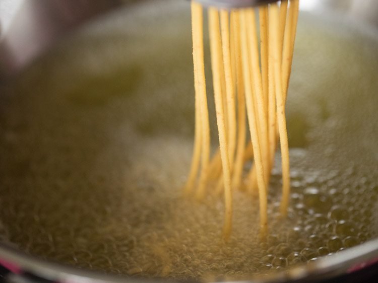 pressing sev maker directly into the oil to fry omapodi. 